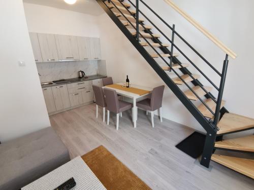 eine Küche und ein Esszimmer mit einem Tisch und Stühlen in der Unterkunft RIS CENTRAL Apartments in Novi Sad