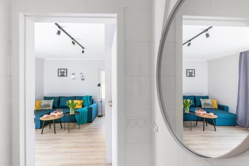 a living room with a blue couch and a mirror at Yellow House Dziwnów in Dziwnów