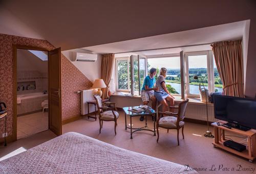 two people sitting in a hotel room with a window at Domaine Le Parc in Danizy