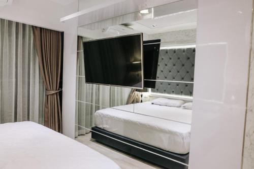 a bedroom with a bed and a flat screen tv at Deamber Bangsare Pattaya in Bang Sare