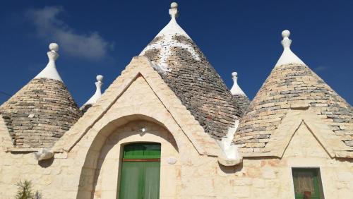 a building with two towers on top of it at Trullo Le Tre Sorelle in Cisternino