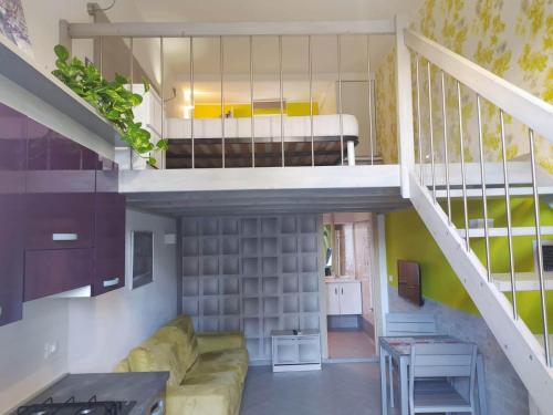 sala de estar con sofá y escalera en Mini Loft Fronte Mare en Pescara