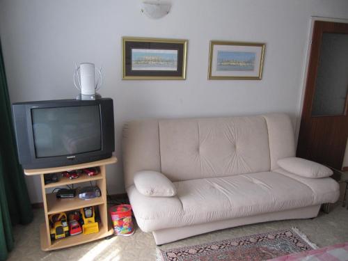 ein Wohnzimmer mit einem Sofa und einem TV in der Unterkunft Apartment Maja in Crikvenica