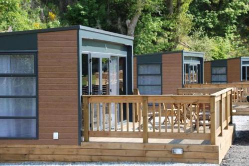 a small cabin with a porch and a deck at Loch Ness Highland Resort in Fort Augustus