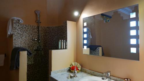 a bathroom with a shower and a sink and a mirror at Dar Sultan in Tangier