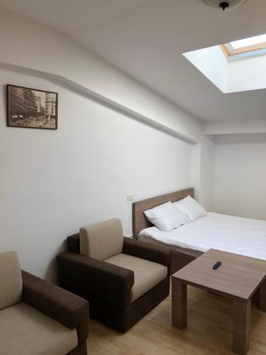 Zimmer mit einem Bett, einem Sofa und einem Tisch in der Unterkunft Gabroveni Aparthotel in Bukarest