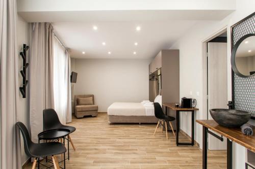 een hotelkamer met een bed en een tafel en stoelen bij Raise The Heraklion Project in Heraklion