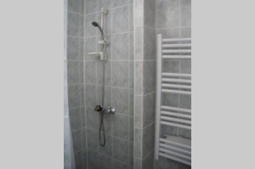 bagno con doccia e piastrelle grigie di LA TRUFFIERE a Castelnau-de-Mandailles