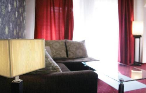 a living room with a couch and a lamp at Penzion Beryl in Košice