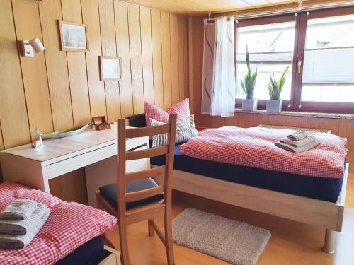 - une chambre avec des lits superposés et un bureau avec une chaise dans l'établissement Fremdenzimmer - Petit Quartier, à Merenberg