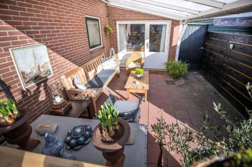 a patio with chairs and tables and a brick wall at Studio Ana- Hata (vanuit het Hart ❤) in Gapinge