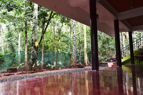 an empty lobby with trees in the background at Jungleview Home Stay in Idukki