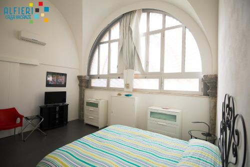 ein Schlafzimmer mit einem Bett und einem großen Fenster in der Unterkunft Casa Vacanze Alfieri in Neapel