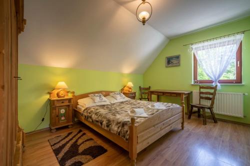 um quarto com paredes verdes, uma cama e uma secretária em Dom Myśliwski em Szklarska Poręba