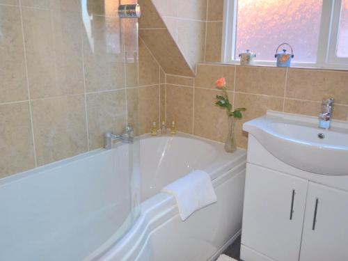 a bathroom with a white tub and a sink at Stylish 3 bedroom apartment in Upton upon Severn