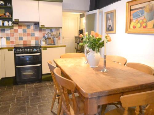 a kitchen with a wooden table with a vase of flowers on it at Stylish 3 bedroom apartment in Upton upon Severn