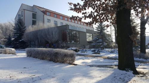 a building with snow in front of it at LH Parkhotel Hluboka Nad Vltavou Congress & Wellness in Hluboká nad Vltavou