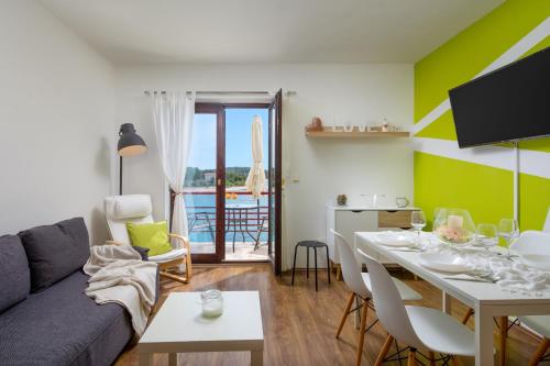 uma sala de estar com um sofá e uma mesa em Apartments Villa Zrinka em Rogoznica