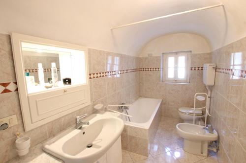 een badkamer met een wastafel, een bad en een toilet bij agriturismo casa santina in Pietrabruna