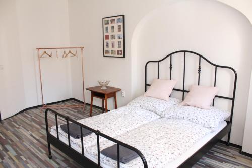 1 dormitorio con cama de metal y almohadas rosas en Schrott Bed&Beer en Brno