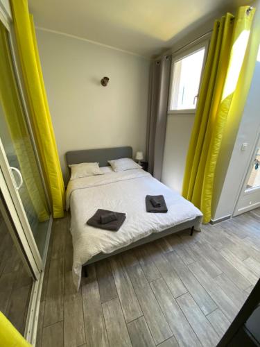 une chambre avec un lit avec deux serviettes dessus dans l'établissement Beau deux pièces sur Gambetta, à Nice