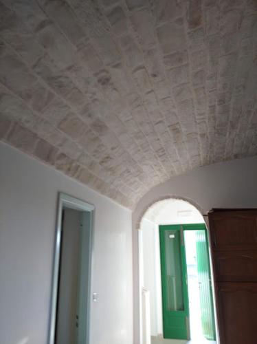 a ceiling in a room with a green door at Trullo Le Tre Sorelle in Cisternino