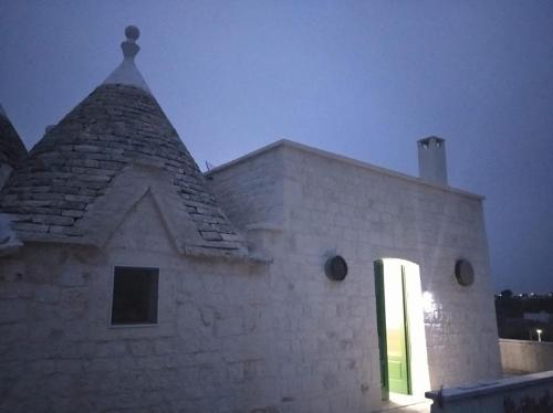 a building with a steeple with a light on it at Trullo Le Tre Sorelle in Cisternino