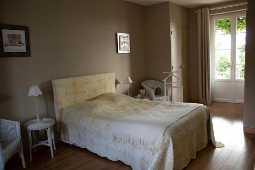 1 dormitorio con 1 cama, 2 sillas y ventana en Chambres d'Hôtes La Pocterie, en Vouneuil-sur-Vienne