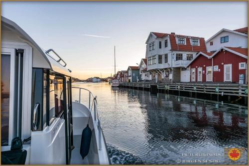 a boat is docked on a river with houses at Hem till Bengt in Kungshamn