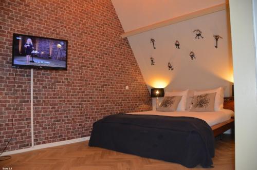 a bedroom with a television and a bed at Hotel de Tabaksplant in Amersfoort