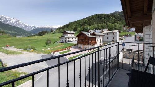 uma varanda com vista para uma aldeia e para as montanhas em Italianway - San Pietro 8 em Valdisotto