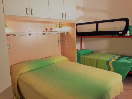 a room with two beds and a double decker bus at RESORT VILLAGE AQUA MARINA FAMILY - Daily Rooms Tidying - CocktailsBar- Pet Friendly - with Hypermarket - Delivery Restaurant-Pizzeria - Room Breakfast with supplement - Ultra Fast Wi-Fi - Play Area for children - Olympic Swimming Pool - Parking in Caorle