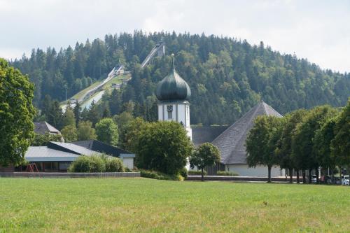 a large white building with a dome on a hill at Hotel Sonne Garni in Hinterzarten