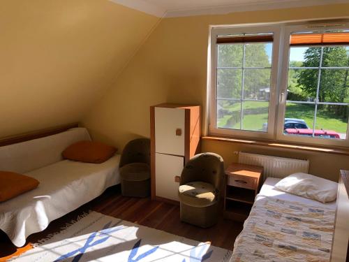 ein kleines Zimmer mit 2 Betten und einem Fenster in der Unterkunft Przystań Stary Folwark in Stary Folwark