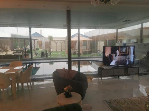a living room with a television and a couch and a table at Alreem challet in Abha