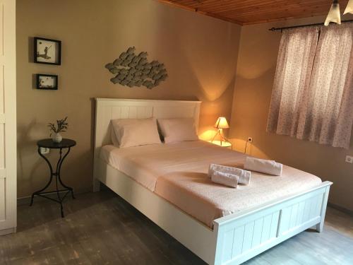 a bedroom with a bed with two pillows on it at Cabernet Houses in Lefkada Town