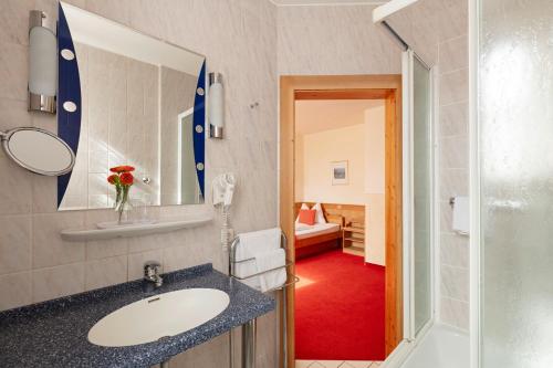 Hotel Hoyacker Hof في جارشينج باي ميونخ: حمام مع حوض ومرآة