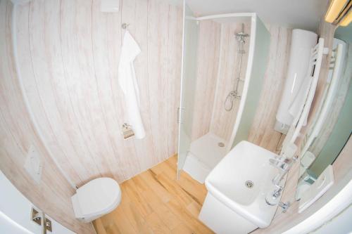 a white bathroom with a toilet and a sink at Obora resort in Lanškroun