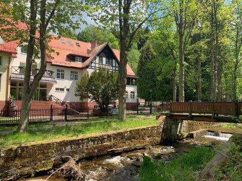 a bridge over a river in front of a house at Willa Jarzębina in Duszniki Zdrój