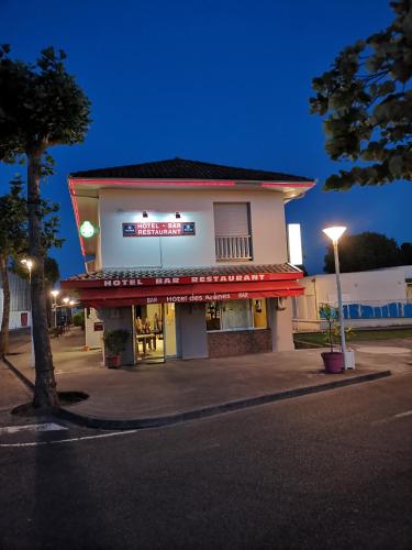 a building with a sign on the side of a street at Hôtel Bar des Arènes in Pontonx-sur-lʼAdour