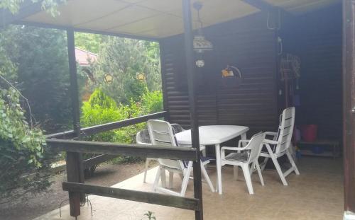 una mesa y sillas en un patio con ventana en Ferienhaus im Donauknie für Familien & Hunde, en Leányfalu