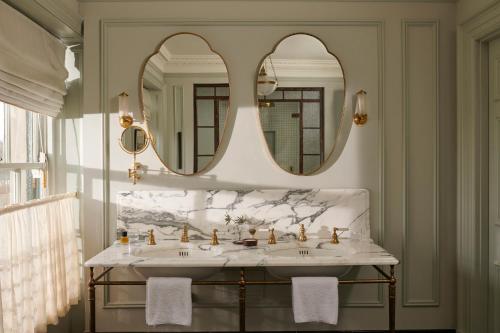 a bathroom with two sinks and two mirrors at The Gleneagles Hotel in Auchterarder
