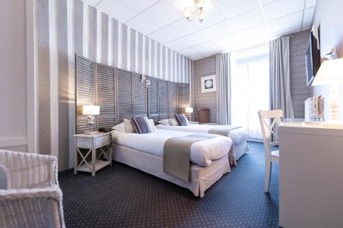una habitación de hotel con 2 camas y una silla en Cit'Hotel Normandy Hotel Pornichet La Baule en Pornichet
