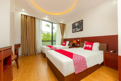 a hotel room with two beds and a window at Super OYO Capital O 387 Bach Duong Hotel in Hanoi