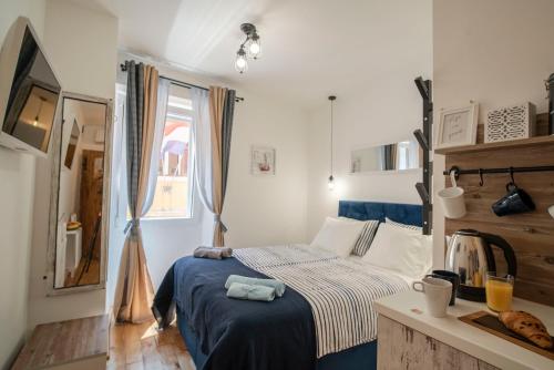 um pequeno quarto com uma cama e uma janela em Stelle D'oro em Rovinj