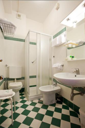 a bathroom with two toilets and a sink at Hotel Splendid in Caorle