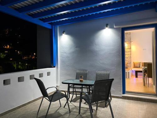 ein Tisch und Stühle auf einem Balkon in der Nacht in der Unterkunft Golden View House in Pera Gyalos