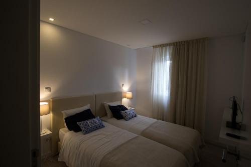 a bedroom with a bed with two pillows on it at Wellshouses in Capelas