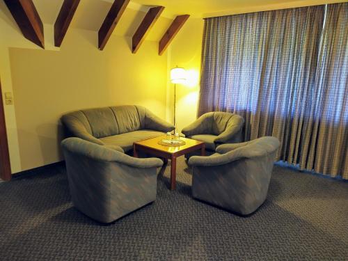 two chairs and a table in a hotel room at Hotel Faller in Breitnau