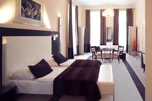 ein Hotelzimmer mit einem Bett, einem Tisch und Stühlen in der Unterkunft Old Town Square Residence by Emblem in Prag